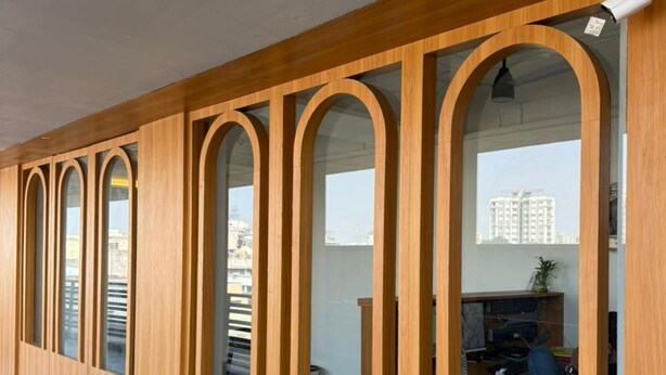 Un edificio moderno con paneles de madera y amplios ventanales arqueados.