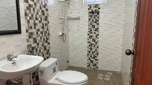 Een douche, handdoeken, zeep, toiletpapier