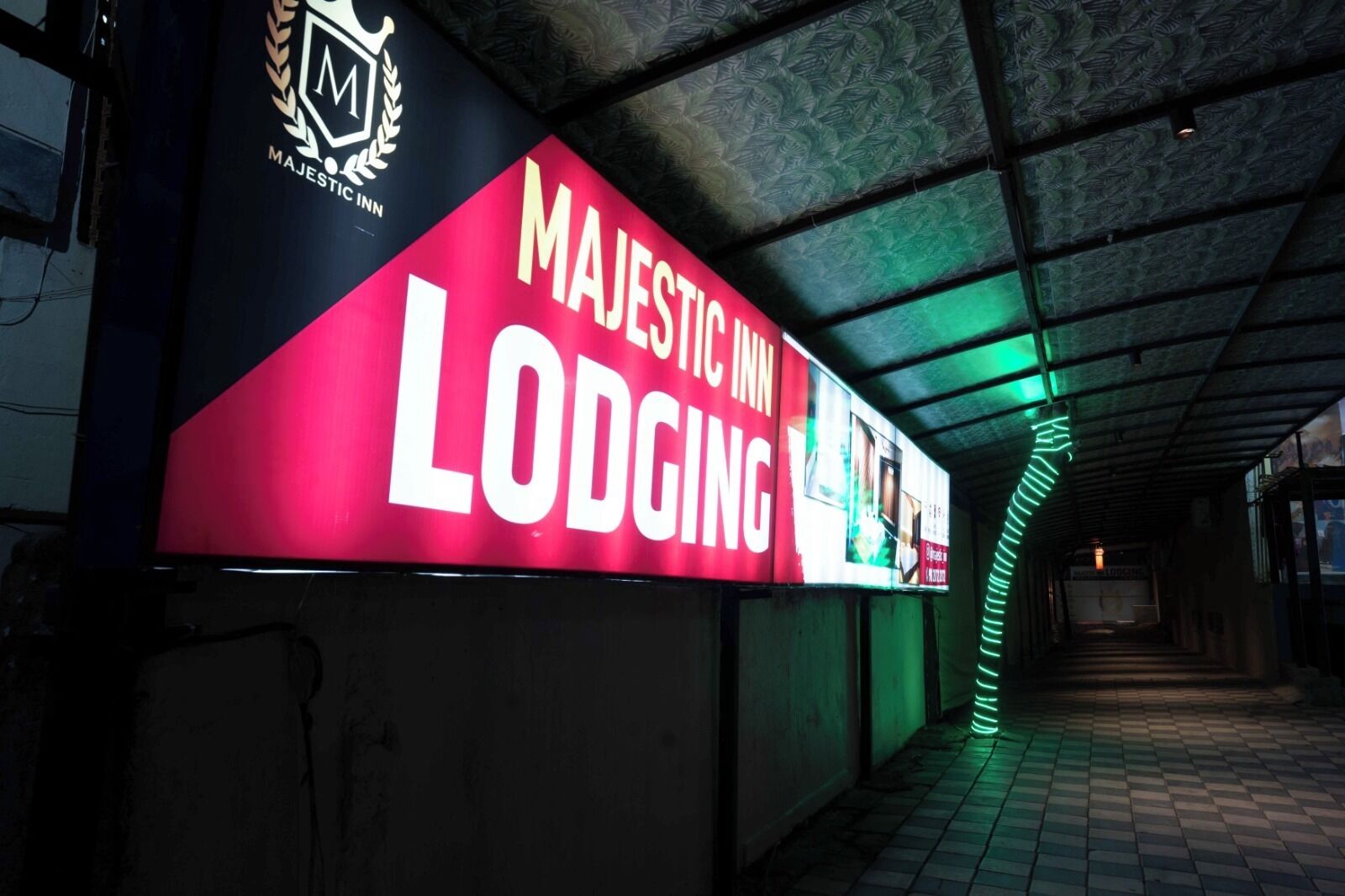 A hallway with a large sign for Majestic Inn Lodging, featuring a logo and text.