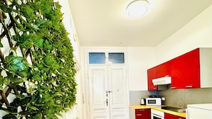 A kitchen with white cabinets, a red countertop, and a microwave. - Comfortable 1BR Lounge Westbahnhof (Vienna)