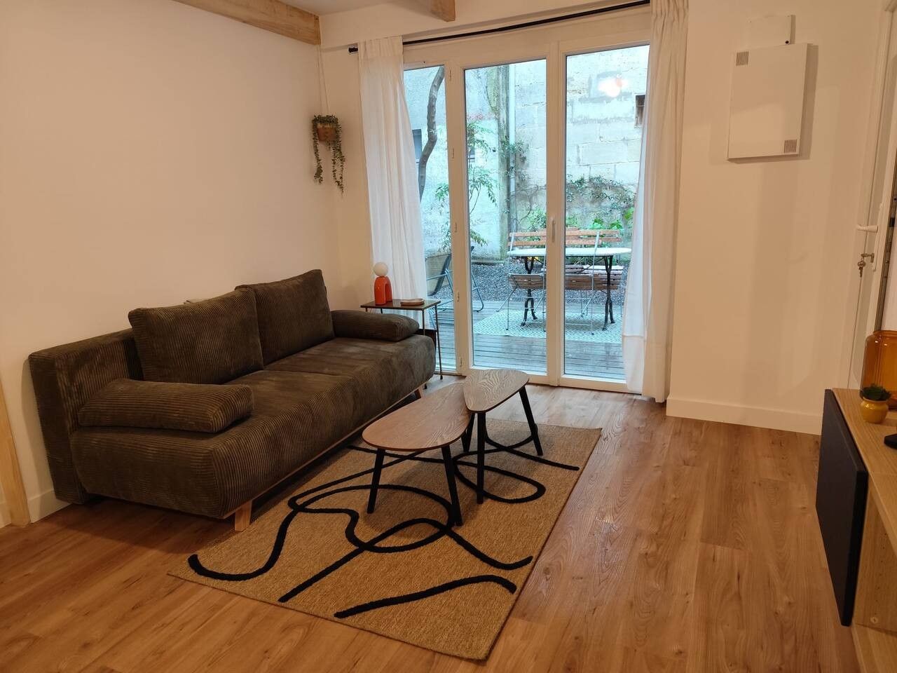 A living room with a sofa, a small table, and a rug.