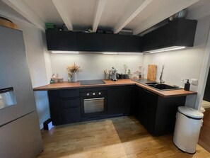 A compact kitchen with a built-in oven, a sink, and a trash bin. - Historic Bordeaux Loft: Charming Apartment in City (Bordeaux)