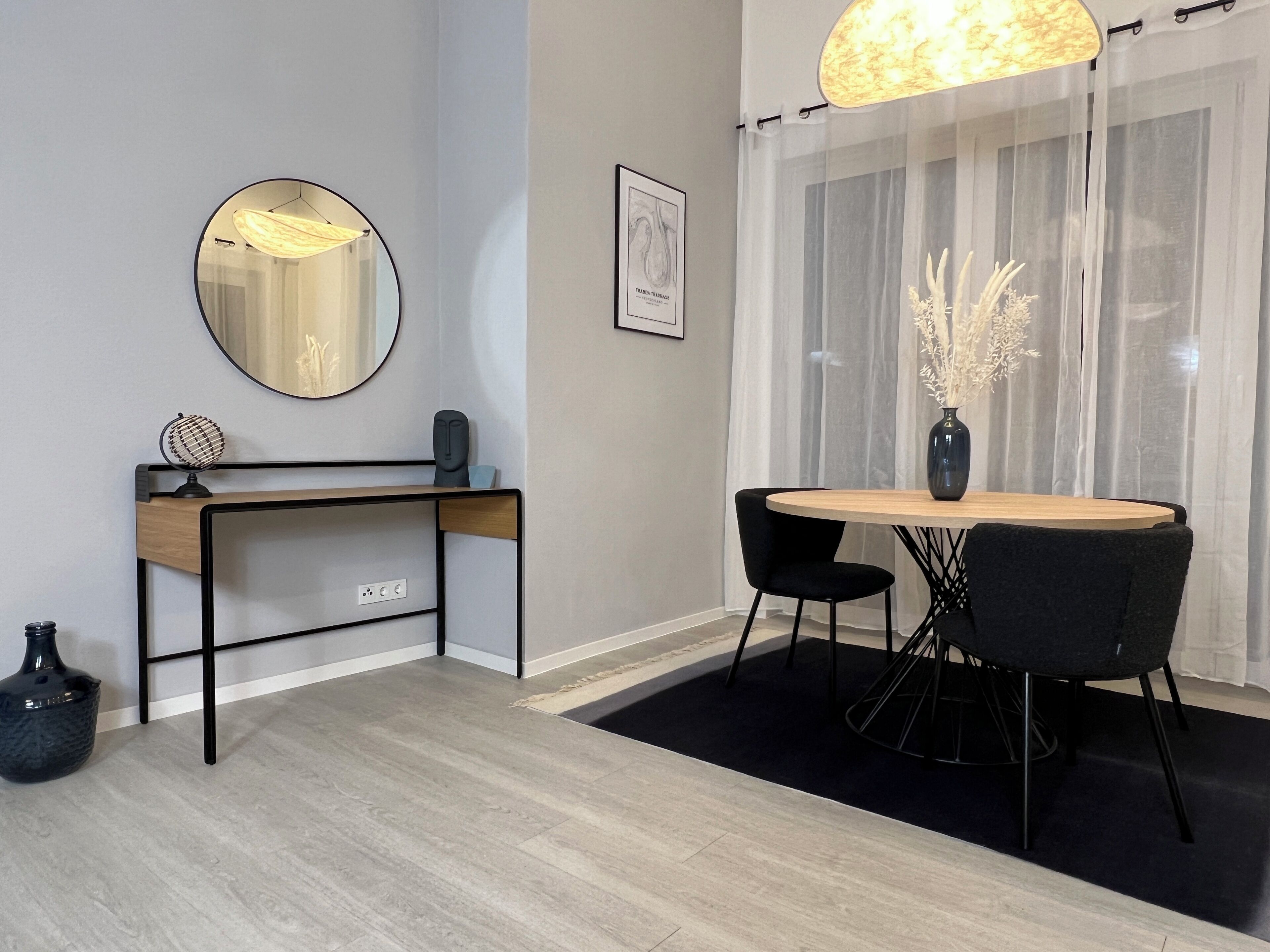A modern room with a desk, chair, and round table.