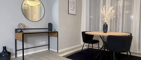 A modern room with a desk, chair, and round table.