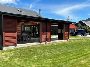 A modern house with a covered patio, a garage, and a driveway. - Stay in Heaven at Lake Hawea (Lake Hāwea)
