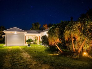 A residential property with a garage, a covered patio, and a well-maintained lawn. - Kaz A Doudou La – 2-bedroom apartment with terrace and garden, tropical calm (Saint-François)