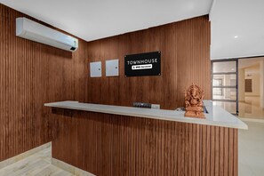 A reception desk with a sign indicating 'Townhouse' and 'OYO-Serviced'. - Classic Hotel Lakshmi's Pride (Kurnool)