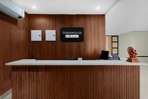 A reception desk with a sign reading 'TOWNHOUSE' and 'OYO-Serviced'.