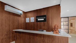 Un mostrador de recepción con un cartel que dice 'TOWNHOUSE' y el logotipo de la empresa.