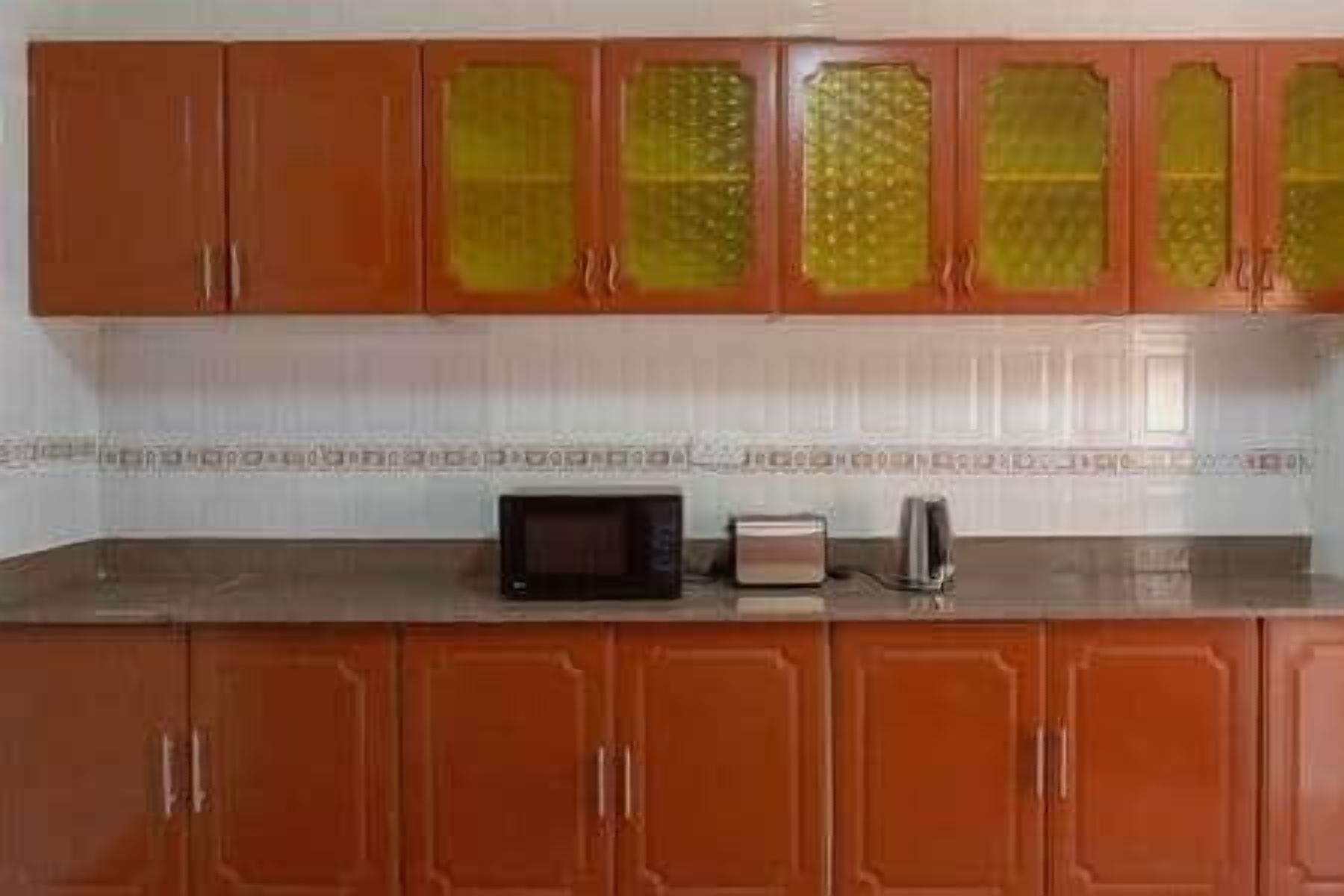 Una cocina con armarios de madera y un microondas sobre la encimera.
