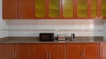 Una cocina con armarios de madera y un microondas sobre la encimera.
