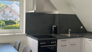 A modern kitchen with a Bosch stove, a sink, and white cabinetry. - Brack vacation apartments in Gaggenau (Gaggenau)