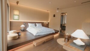 Une chambre à coucher moderne avec un grand lit, des tables de chevet et une plateforme en bois.