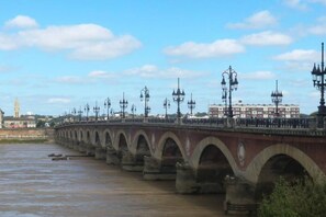 A bridge with multiple arches and street lamps. - Studio hyper centre historique Quai bourgeois (Bordeaux)