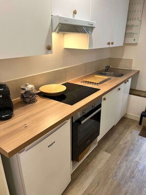A compact kitchen with a built-in oven, a coffee maker, and a toaster. - Very nice apartment with garden (Bordeaux)