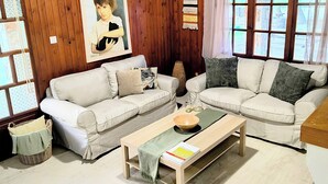 A cozy living room with two white sofas, a wooden coffee table, and a framed picture on the wall. - The Farm House Cozy Country Stay Close to the Sea (Παραλία Μαραθώνα)