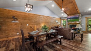 Interior de madera con una mesa de comedor, bancos y una chimenea.