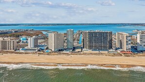 Un paisaje urbano costero con rascacielos, una playa de arena y una vista despejada del océano.
