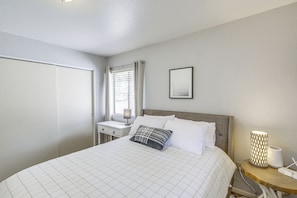 A bedroom with a bed, a bedside table, a lamp, and a picture on the wall. - Forest-front Munds Park Cabin w/ ATV Access (Munds Park)