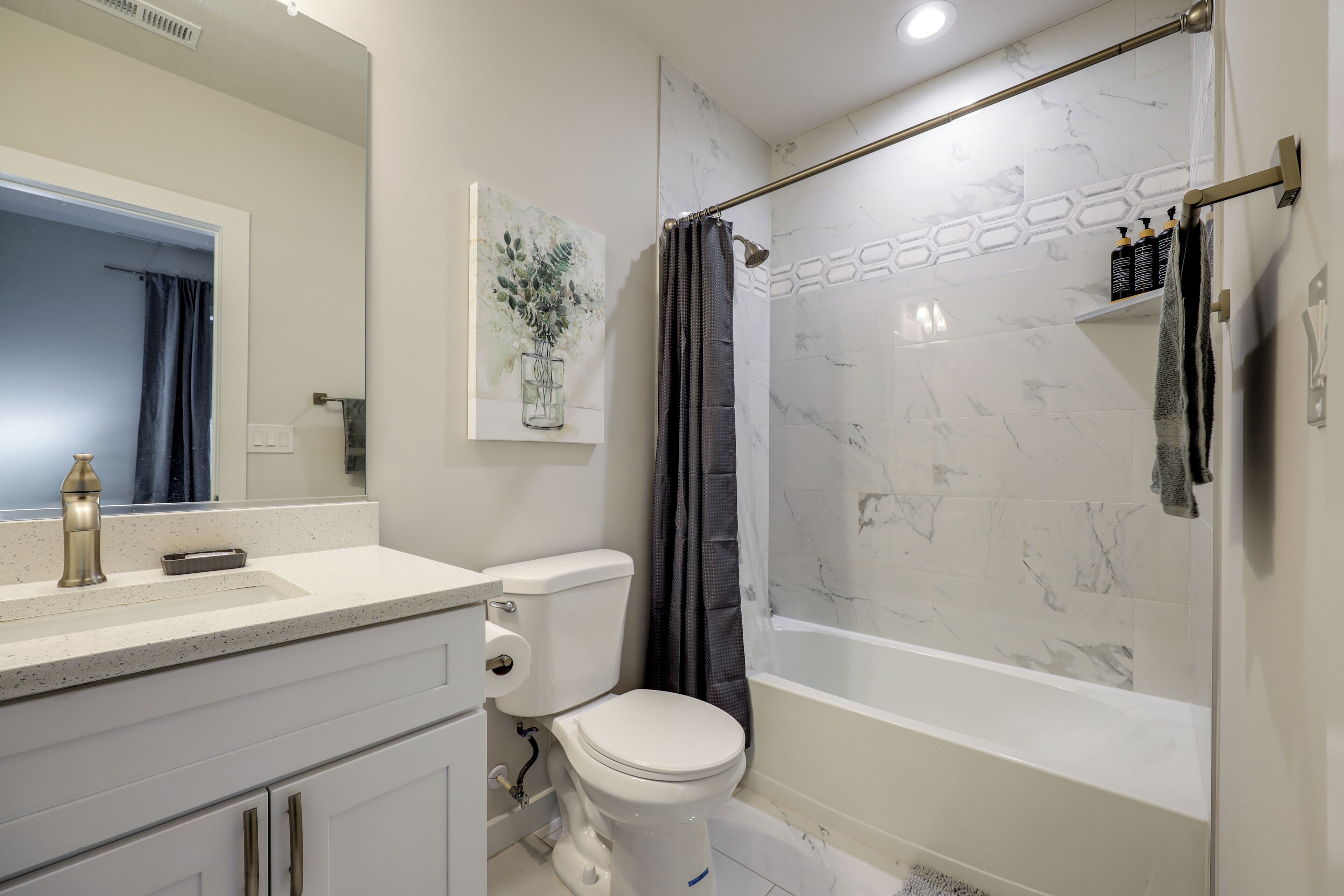 A modern bathroom with a toilet, sink, and shower.