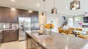 A modern kitchen with granite countertops, stainless steel appliances, and pendant lighting. - 11 Mi to the Strip: Quiet Home in North Las Vegas (North Las Vegas)