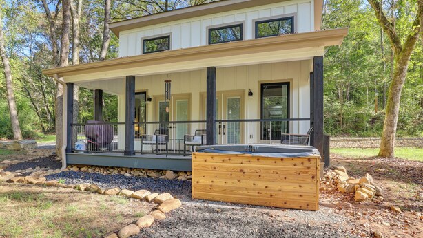 A modern two-story house with a covered porch, outdoor seating, and a hot tub. - Whitewood w/ Hot Tub: Peaceful Wildwood Retreat (Wildwood)