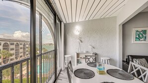 Ein moderner Essbereich mit großem Fenster, einem weißen Tisch und Blick auf eine Brücke.