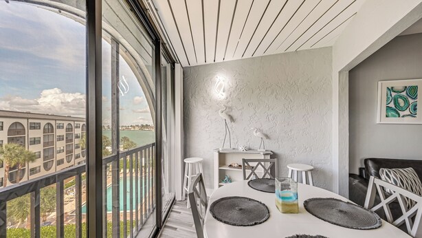 Un espace repas moderne avec une grande fenêtre, une table blanche et une vue sur un pont.