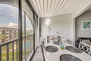 A modern dining area with a large window, a white table, and a view of a bridge. - 2 Mi to Beach! Unit w/ Pool Access on Marco Island (Marco Island)