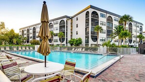 Un hôtel doté d’une piscine, d’un espace extérieur aménagé et d’un immeuble à plusieurs étages avec des balcons.