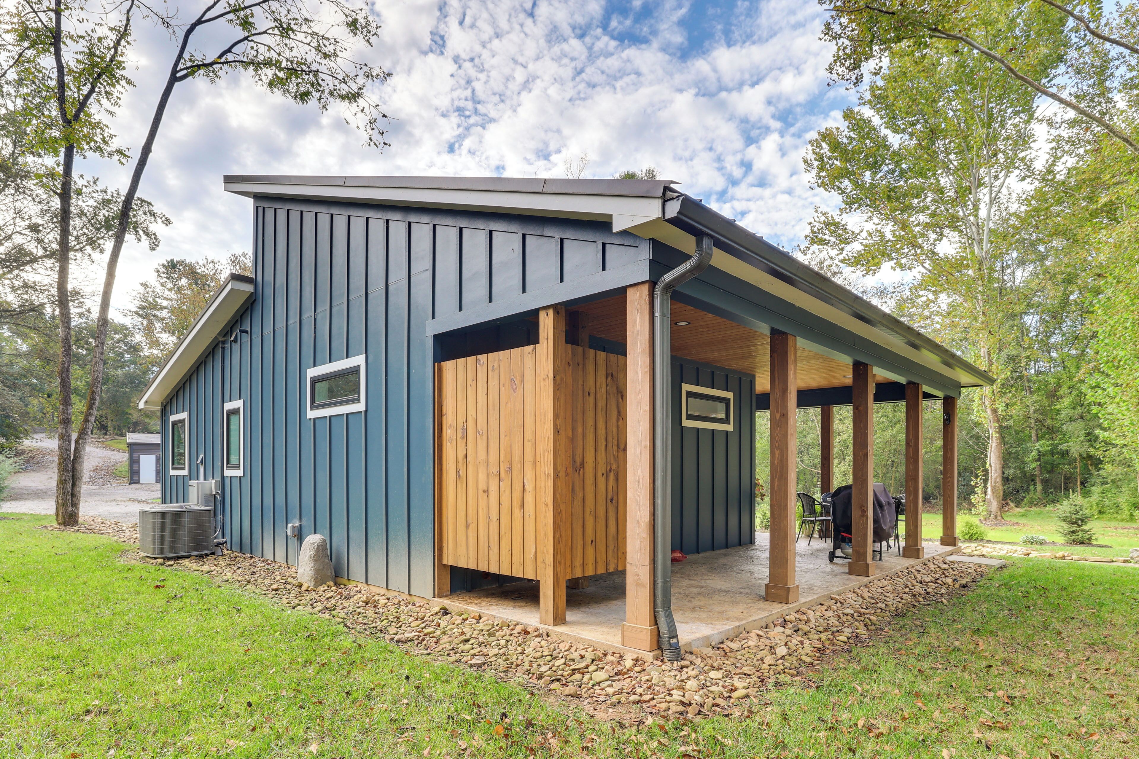 A modern building with a covered porch and a stone foundation.
