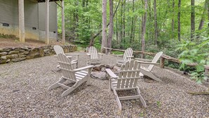 A wooden deck with Adirondack chairs, surrounded by a forested area. - Modern Mountain Zen 3-bed, 3-bath Home With Creeks (Sapphire)
