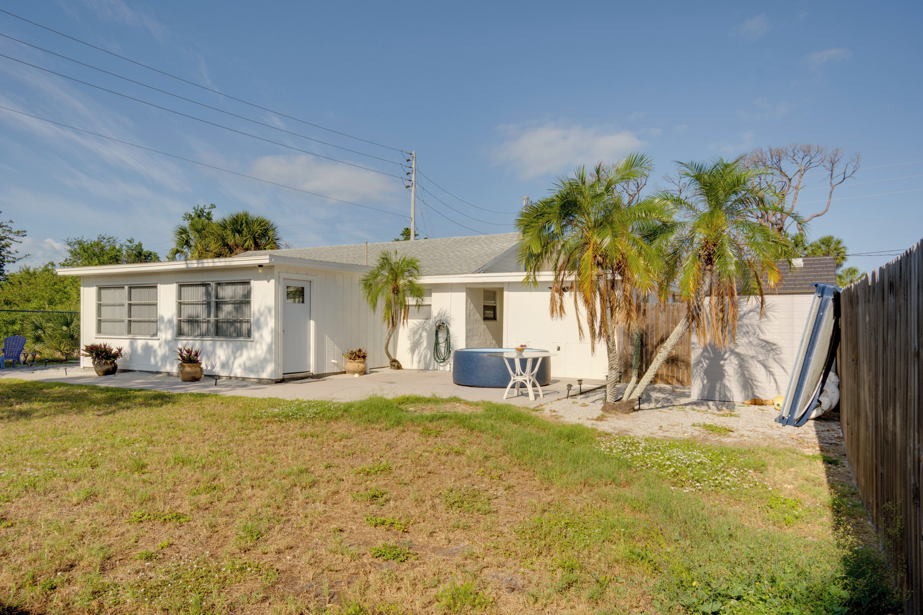 A single-story house with a front porch, a small patio, and a fenced backyard.