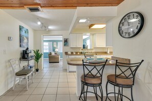 A kitchen with a bar area, a dining table with chairs, and a wall clock. - 2 Mi to Manasota Key Beaches: Coastal Getaway (Englewood)