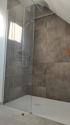 Een douche, handdoeken, zeep, toiletpapier