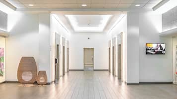 Un couloir moderne avec une lucarne, un plancher en bois et une œuvre d’art encadrée accrochée au mur.