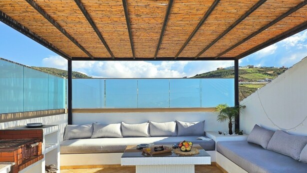 A covered outdoor seating area with a sofa, a coffee table, and a view of the landscape. - Villa with pool, sea and mountain view - Tangier (Tanger-Tétouan-Al Hoceima)
