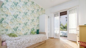 Une chambre à coucher avec un lit, une armoire et une chaise rouge.