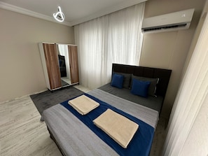 A hotel room with a bed, a mirror, a wardrobe, and an air conditioning unit. - ALAS GARDEN APART OTEL FETHİYE  (Fethiye)