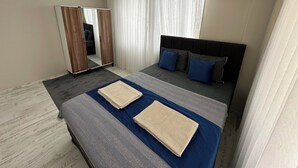 Habitación de hotel con cama, armario, espejo y aire acondicionado.