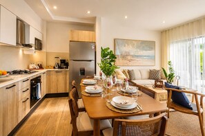 A modern kitchen with a dining area, wooden cabinets, and a large window.