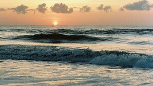 A sunset over the ocean with waves. - King Bed • Pool • Chic • Kitchenette • Patio   • FB 9 Min Walk • Beach 3 Min Drive (Fernandina Beach)