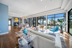 A spacious living area with a modern design, large windows, and a view of the outdoors. - 4011 Big Little Lies - Modern, Oceanfront Home (Carmel)