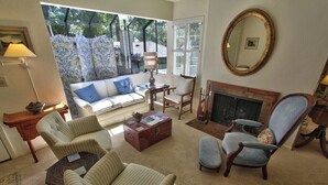 A living room with a sofa, armchairs, a coffee table, a fireplace, and a large mirror. - 4023 Monte Verde Sanctuary - Sweet Carmel Home (Carmel)