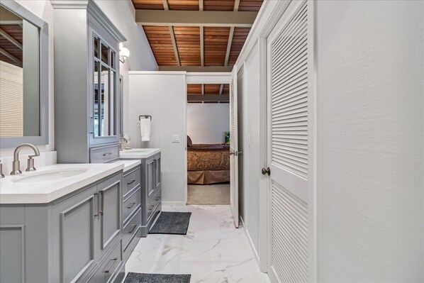 Un baño con un espejo grande, dos lavamanos y un mueble de tocador.