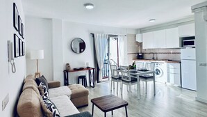 Un salon moderne comprenant un canapé, une table basse et un coin repas avec des chaises.