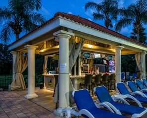 A covered outdoor bar area with seating and a counter. - 25% Off 7BR Theme Villa! Pool/Spa/GameRoom (Davenport)