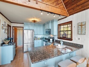 A kitchen with granite countertops, stainless steel appliances, and light blue cabinetry. - Chalet on Smith Lake - perfect lakeside retreat! (Crane Hill)