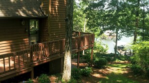 A wooden cabin with a deck overlooking a lake, surrounded by trees. - Chalet on Smith Lake - perfect lakeside retreat! (Crane Hill)
