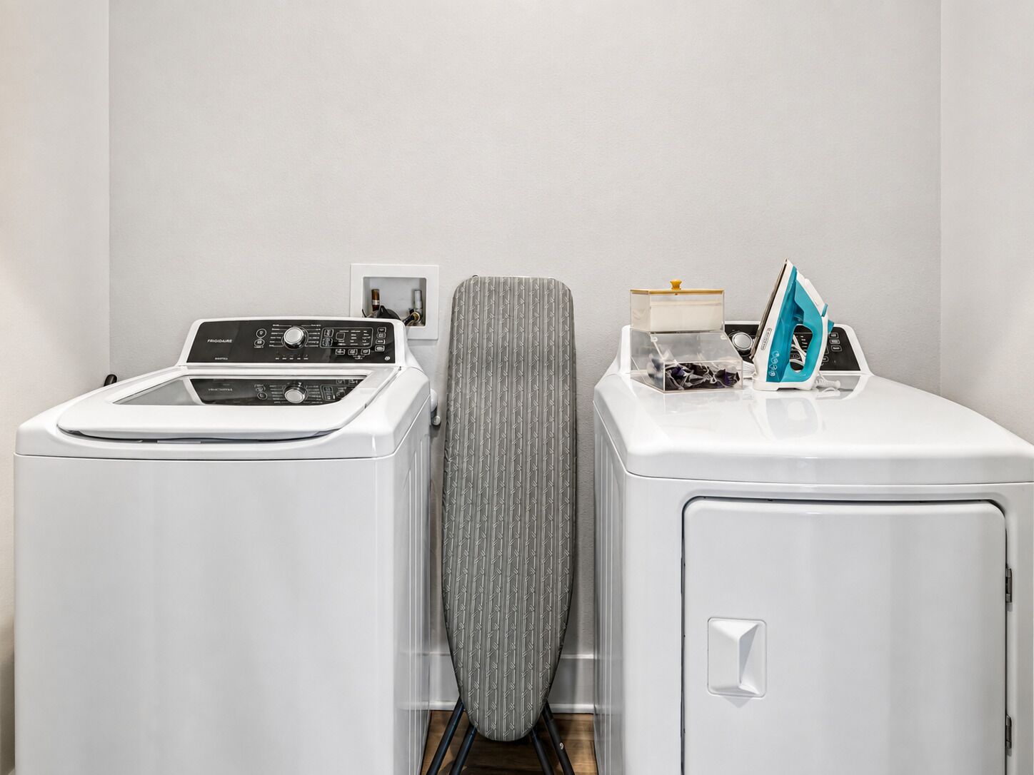 A laundry area with a front-loading washer, a dryer, and a utility cabinet.